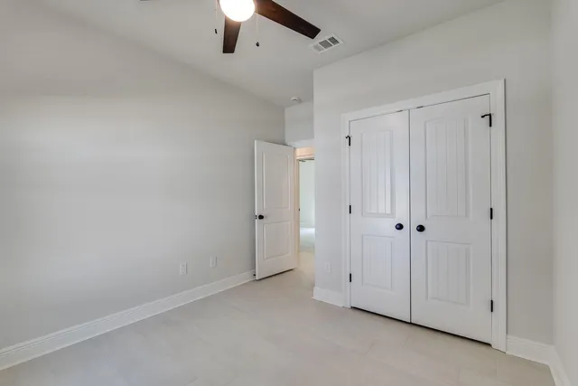an empty room with a window and ceiling fan