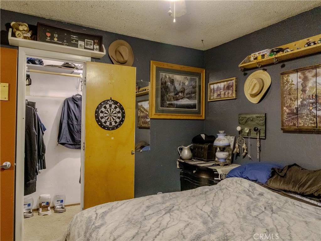 9413 Garfield Street Riverside, CA 92503 - Photo 18 of 33 a bedroom with a bed and a lamp on dresser
