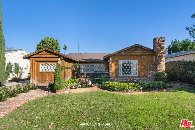 a front view of a house with a yard and potted plants