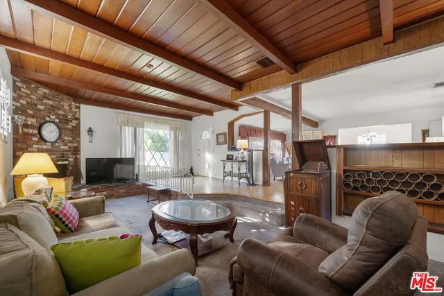 a living room with furniture a fireplace and a chandelier