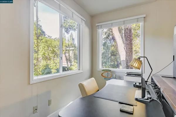 a view of a workspace with furniture and a window