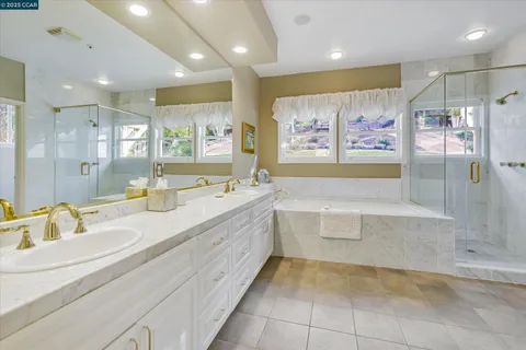 a spacious bathroom with a tub sink and mirror