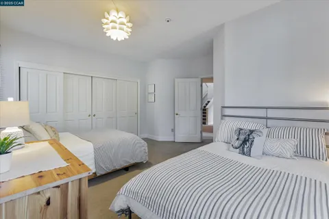 a bedroom with two beds and a chandelier
