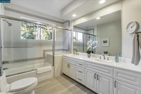 a bathroom with a granite countertop sink toilet tub and shower