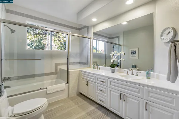 a bathroom with a granite countertop sink toilet tub and shower