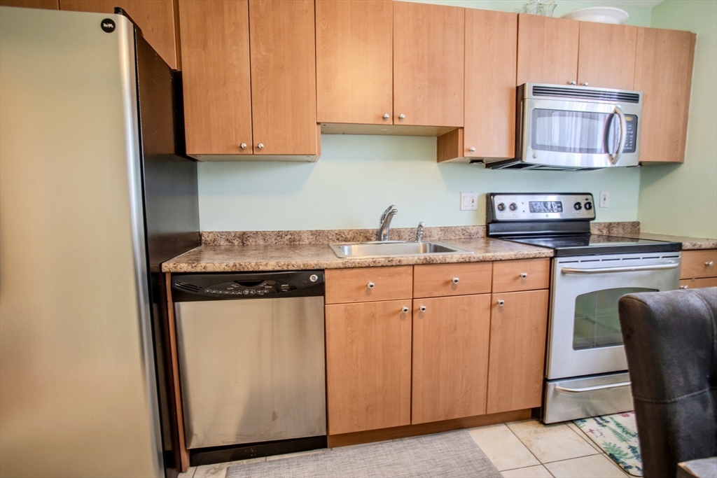15 Westgate Road, Unit 6 Chestnut Hill, MA 02467 - Photo 5 of 20 a kitchen with stainless steel appliances granite countertop a sink stove and cabinets