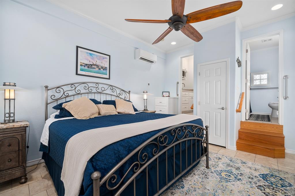 515 Copano Cove Road Rockport, TX 78382 - Photo 31 of 39 a bedroom with a bed and a chandelier
