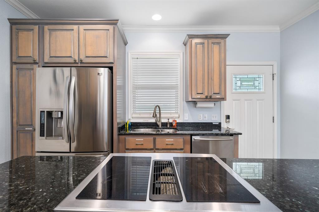 515 Copano Cove Road Rockport, TX 78382 - Photo 10 of 39 a kitchen with stainless steel appliances granite countertop a refrigerator a stove and a sink with wooden floor