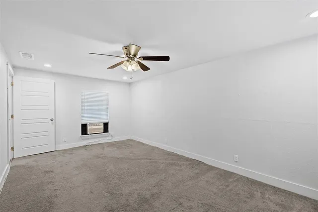 an empty room with closet and windows