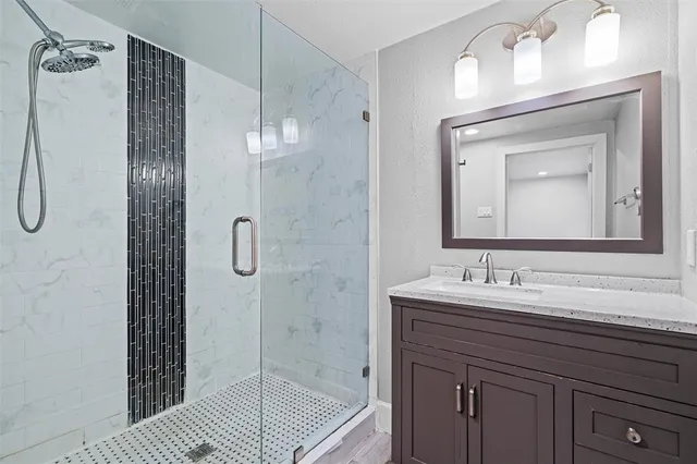 a bathroom with a sink a vanity a mirror a vanity and shower