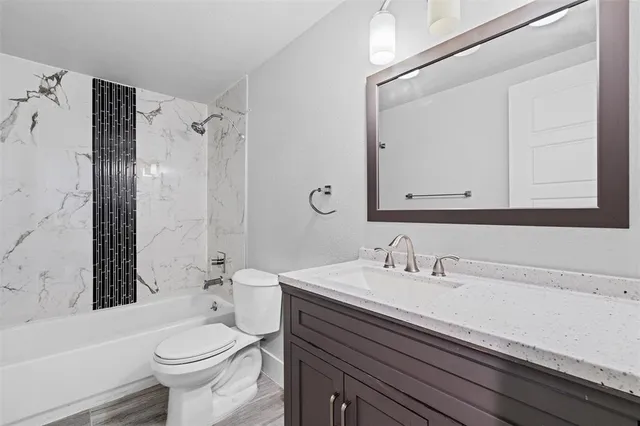 a bathroom with a sink a toilet a mirror and shower