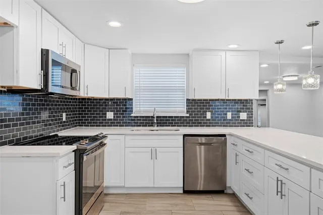 a kitchen with stainless steel appliances granite countertop a sink stove and cabinets