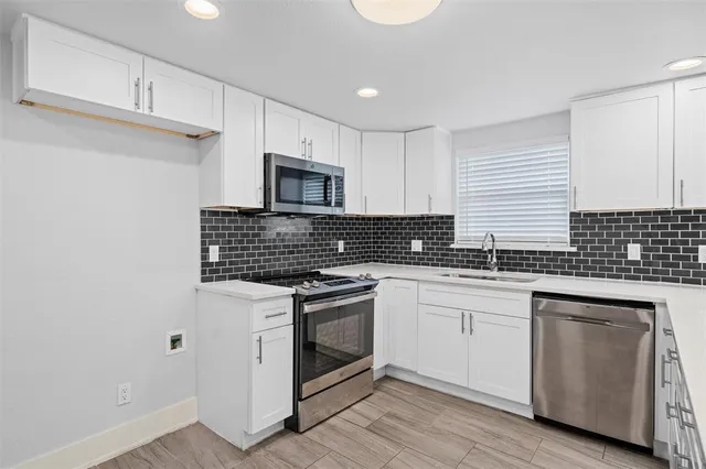a kitchen with sink a microwave and cabinets