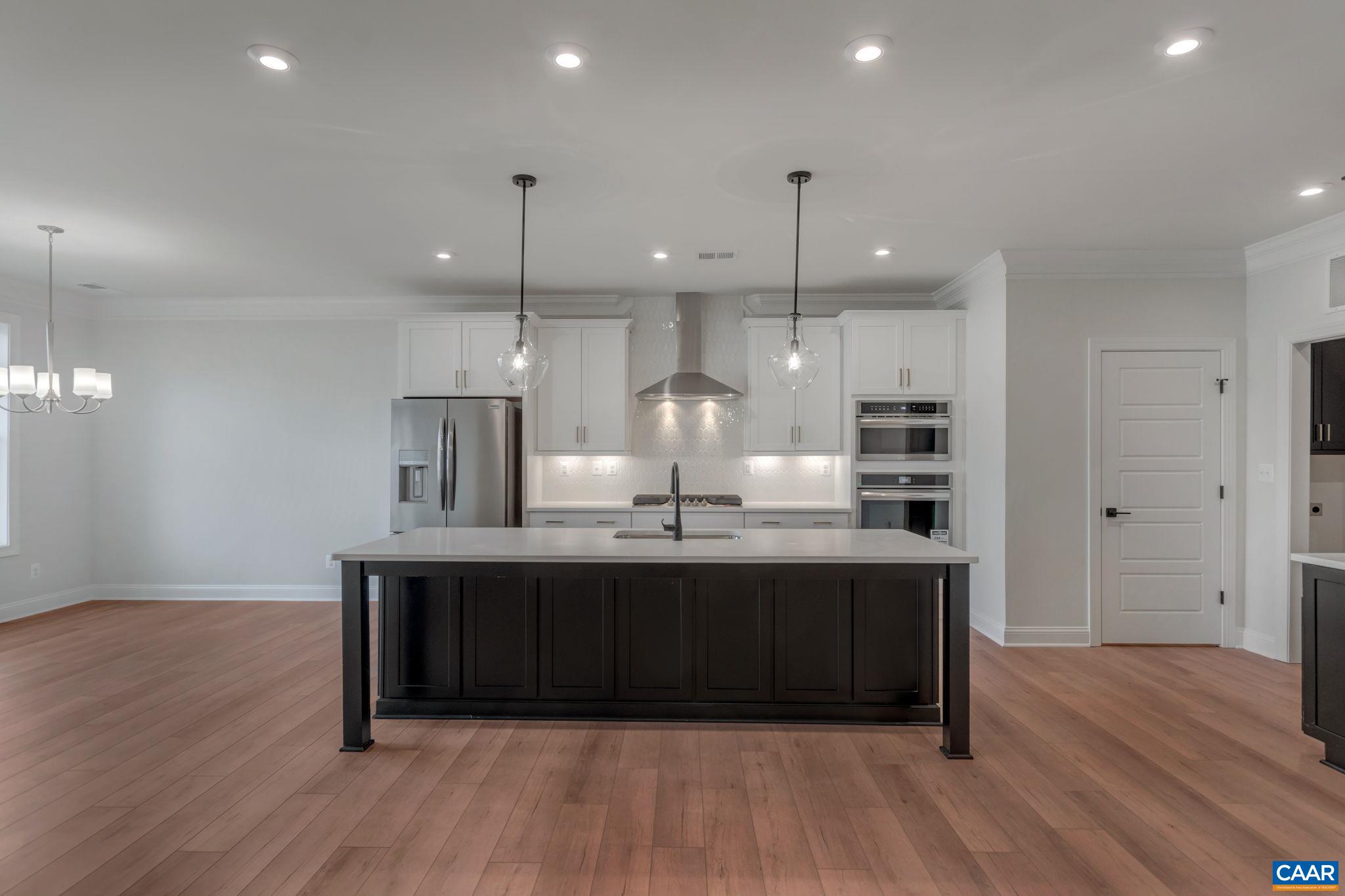 3012 Miranda Crossing Charlottesville, VA 22901 - Photo 15 of 57 a kitchen with kitchen island stainless steel appliances a sink cabinets and wooden floor