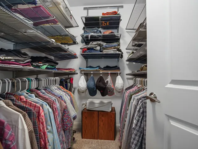 a view of walk in closet with clothes and shoes