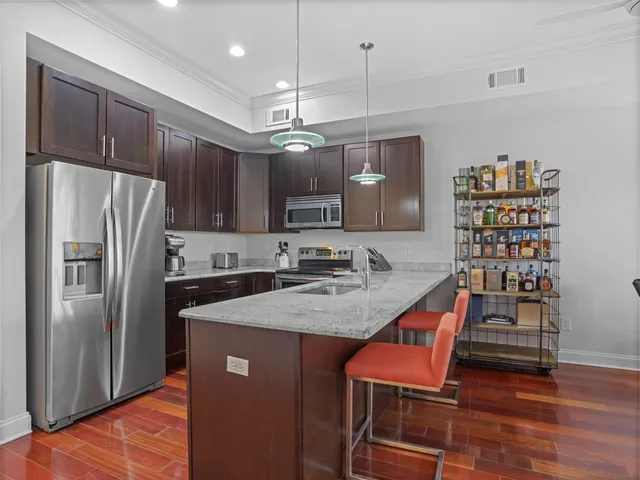 a kitchen with stainless steel appliances granite countertop a sink refrigerator and microwave