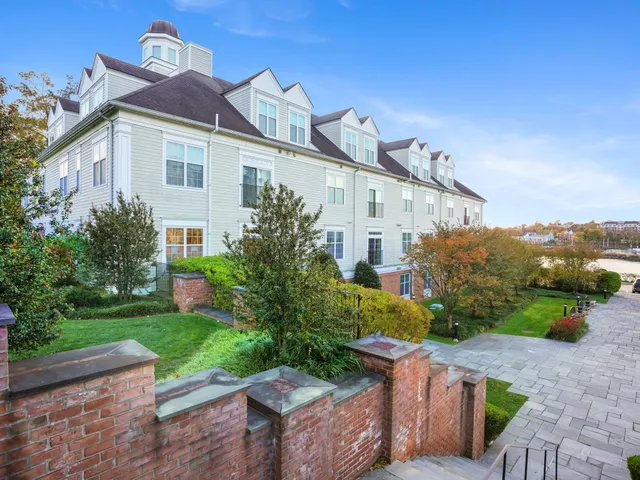 a view of a white house with a yard and potted plants