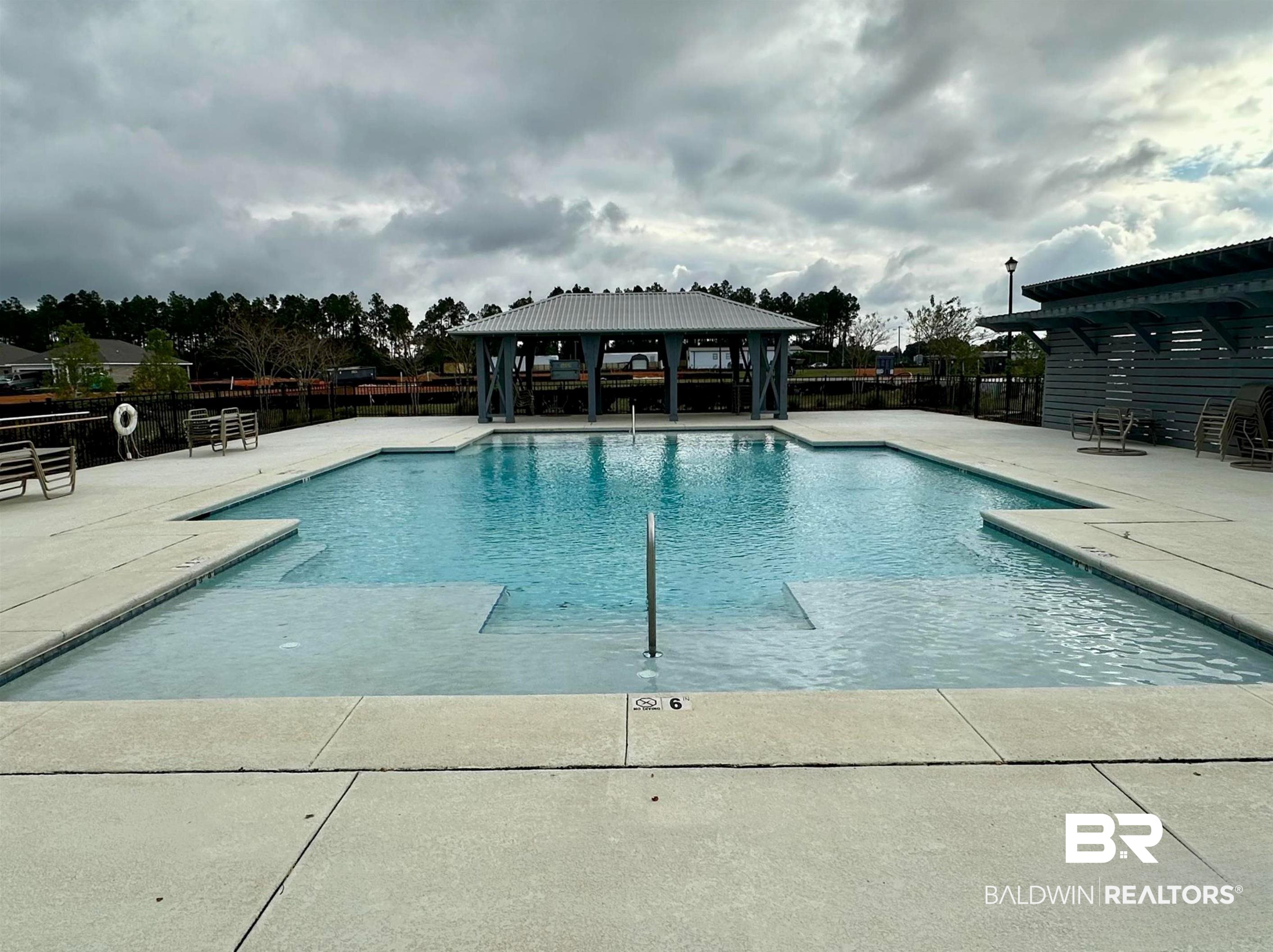 1040 Hayward Loop Foley, AL 36535 - Photo 32 of 35 Community swimming pool featuring a perimeter fence and concrete deck