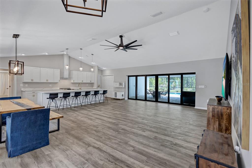 13362 Downy Woodpecker Road Weeki Wachee, FL 34614 - Photo 4 of 26 a view of a room with wooden floor and a ceiling fan
