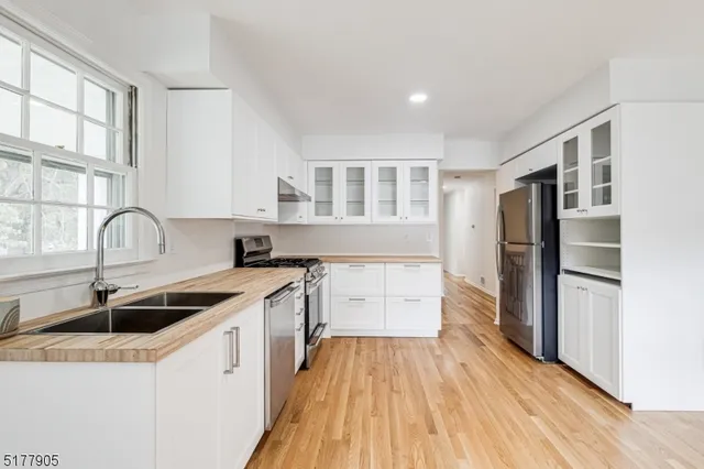 a kitchen with a sink a refrigerator and cabinets