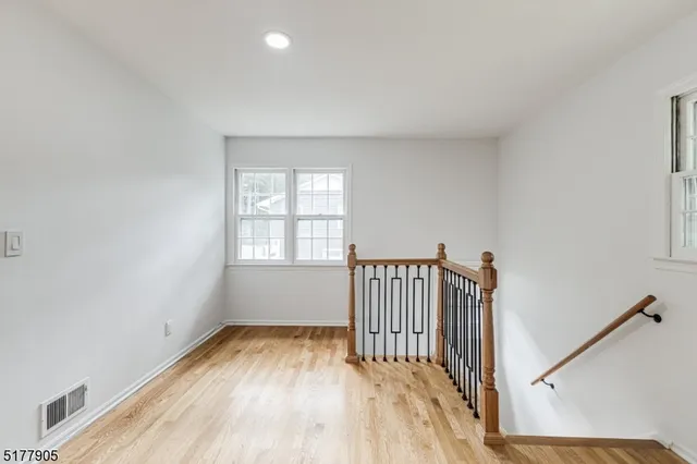 a view of a room with wooden floor and windows
