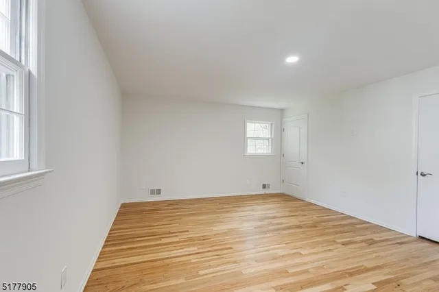 a view of a room with wooden floor and window