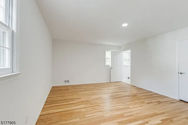 a view of a room with wooden floor and white walls