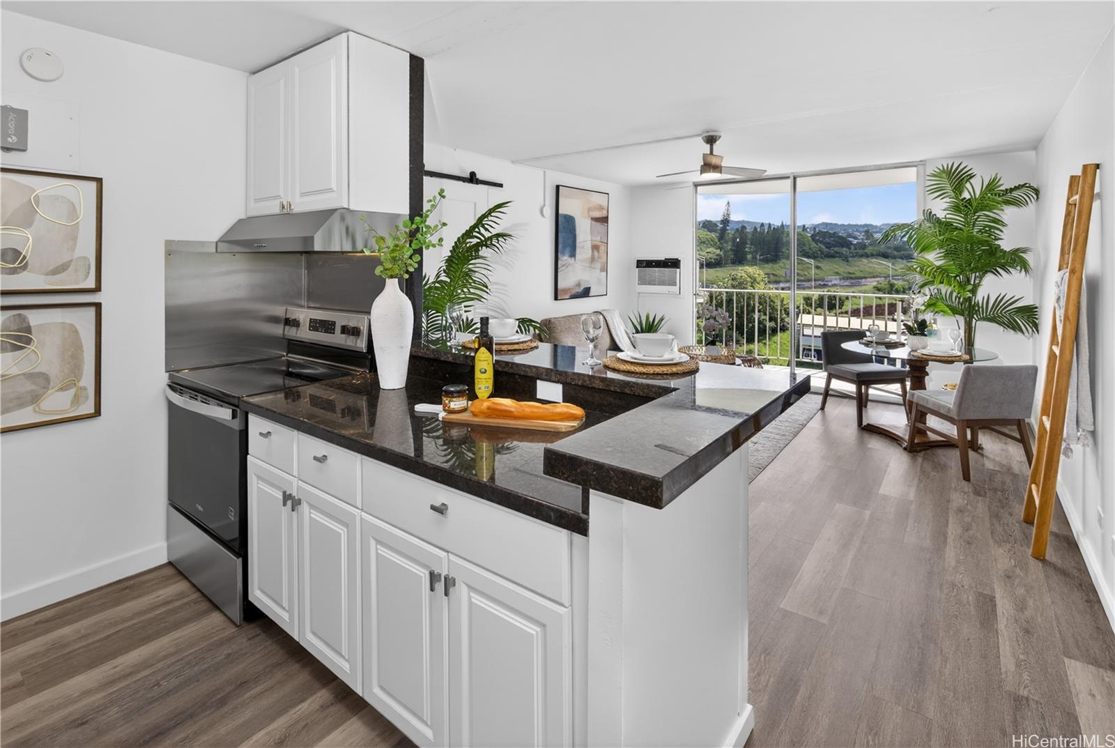 98-1038 Moanalua Road, Unit 7608 Aiea, HI 96701 - Photo 6 of 25 a kitchen with kitchen island a counter space a sink stove and wooden floor
