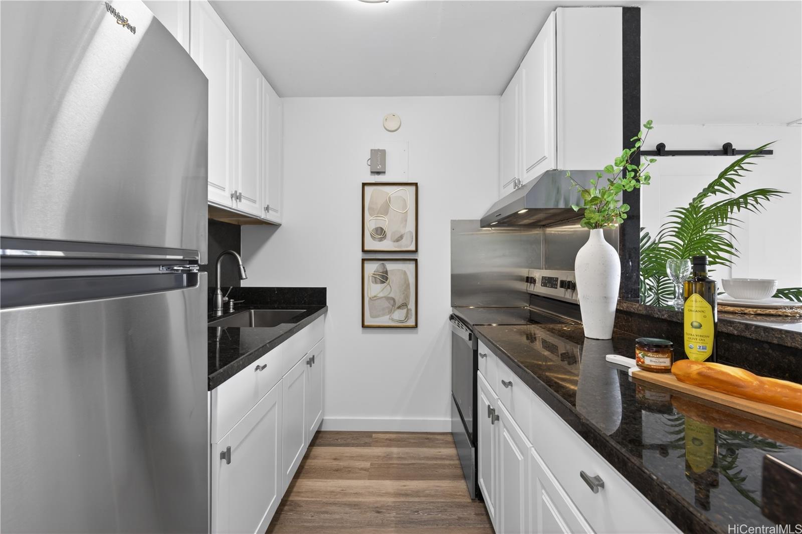 98-1038 Moanalua Road, Unit 7608 Aiea, HI 96701 - Photo 7 of 25 a kitchen with stainless steel appliances granite countertop a refrigerator a stove and a sink
