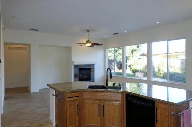 a kitchen with granite countertop a sink and a stove top oven