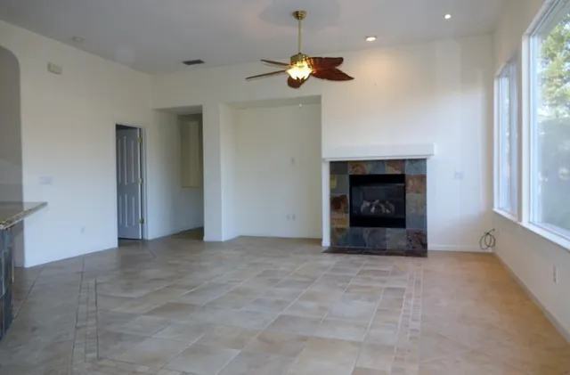 an empty room with a fireplace and fan