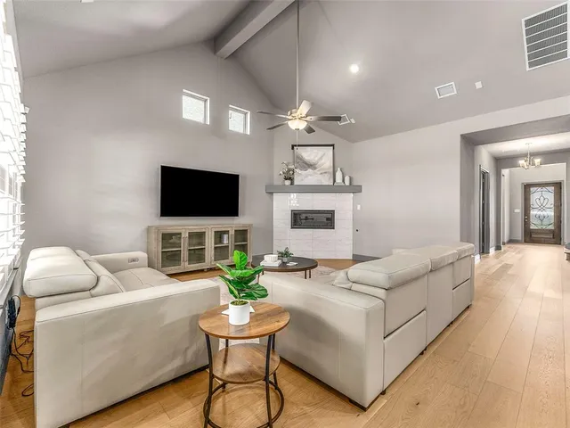 a living room with furniture a flat screen tv and a fireplace