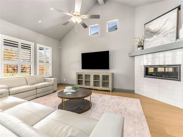 a living room with furniture a flat screen tv and a large window