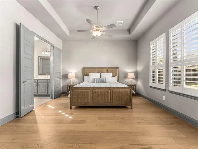 a bedroom with a large bed and a chandelier fan