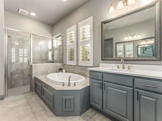 a bathroom with a tub a sink and mirror