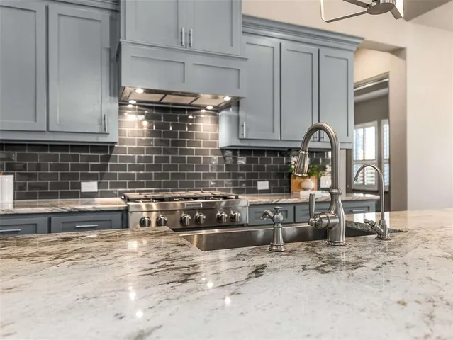 a kitchen with granite countertop a stove and a wooden cabinets