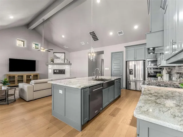 a large kitchen with stainless steel appliances kitchen island granite countertop a large counter top and oven