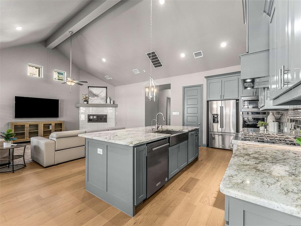 1930 Inwood Lane Prosper, TX 75078 - Photo 7 of 37 a large kitchen with stainless steel appliances kitchen island granite countertop a large counter top and oven