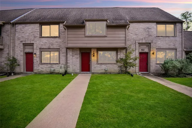 a front view of a house with a garden and plants