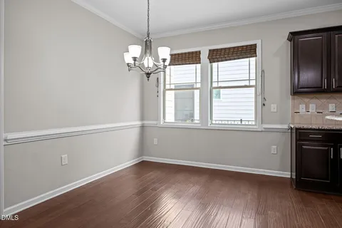 a view of a big room with wooden floor and windows