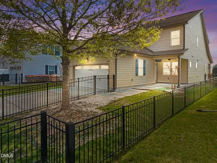 a view of a house with large windows and a small yard