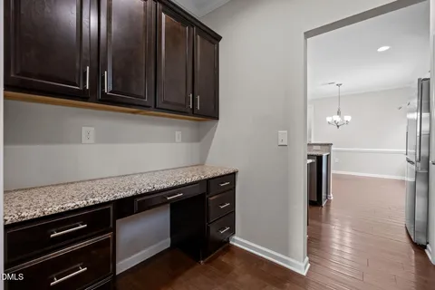 an empty room with wooden floor fireplace and windows