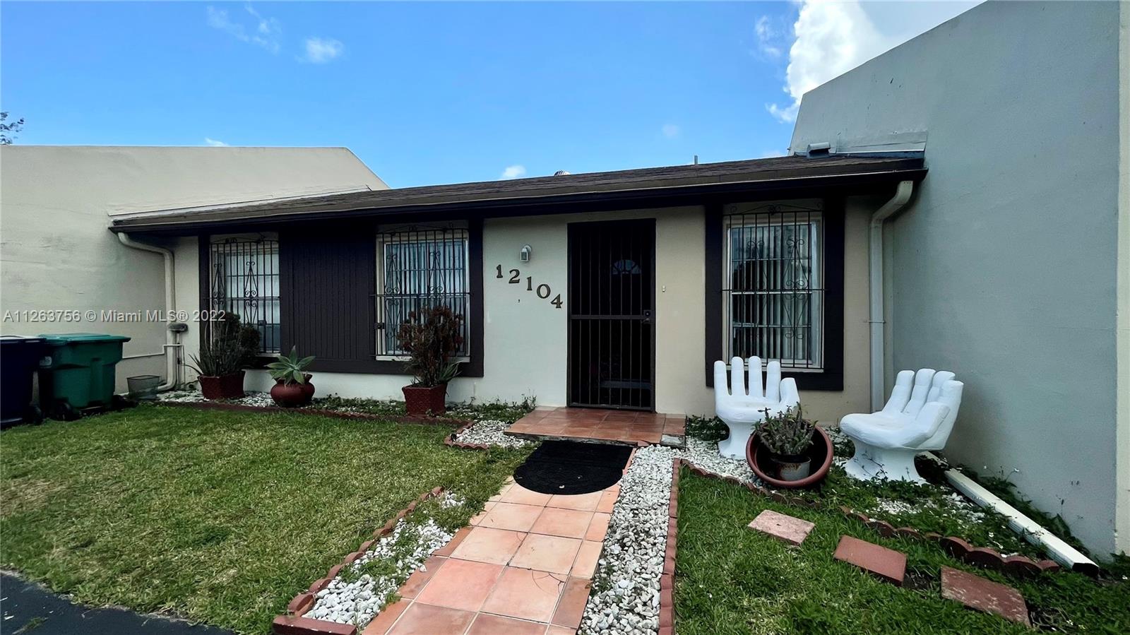 12104 Southwest 110th St Circle South Miami, FL 33186 - Photo 2 of 8 a view of a chair and table in backyard of the house