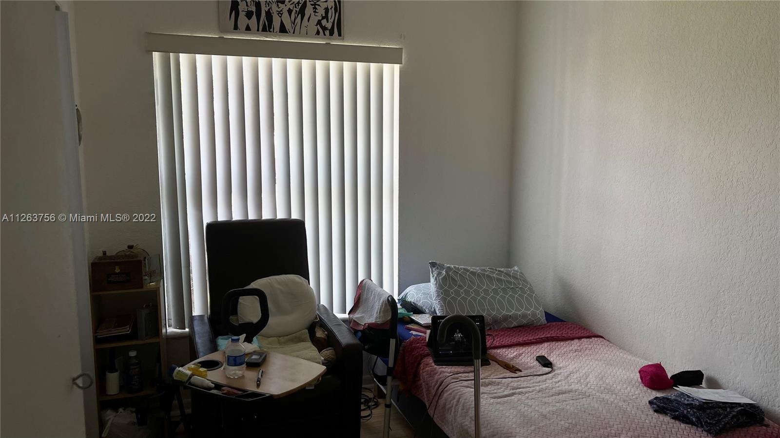 12104 Southwest 110th St Circle South Miami, FL 33186 - Photo 5 of 8 a bedroom with a bed and a chair