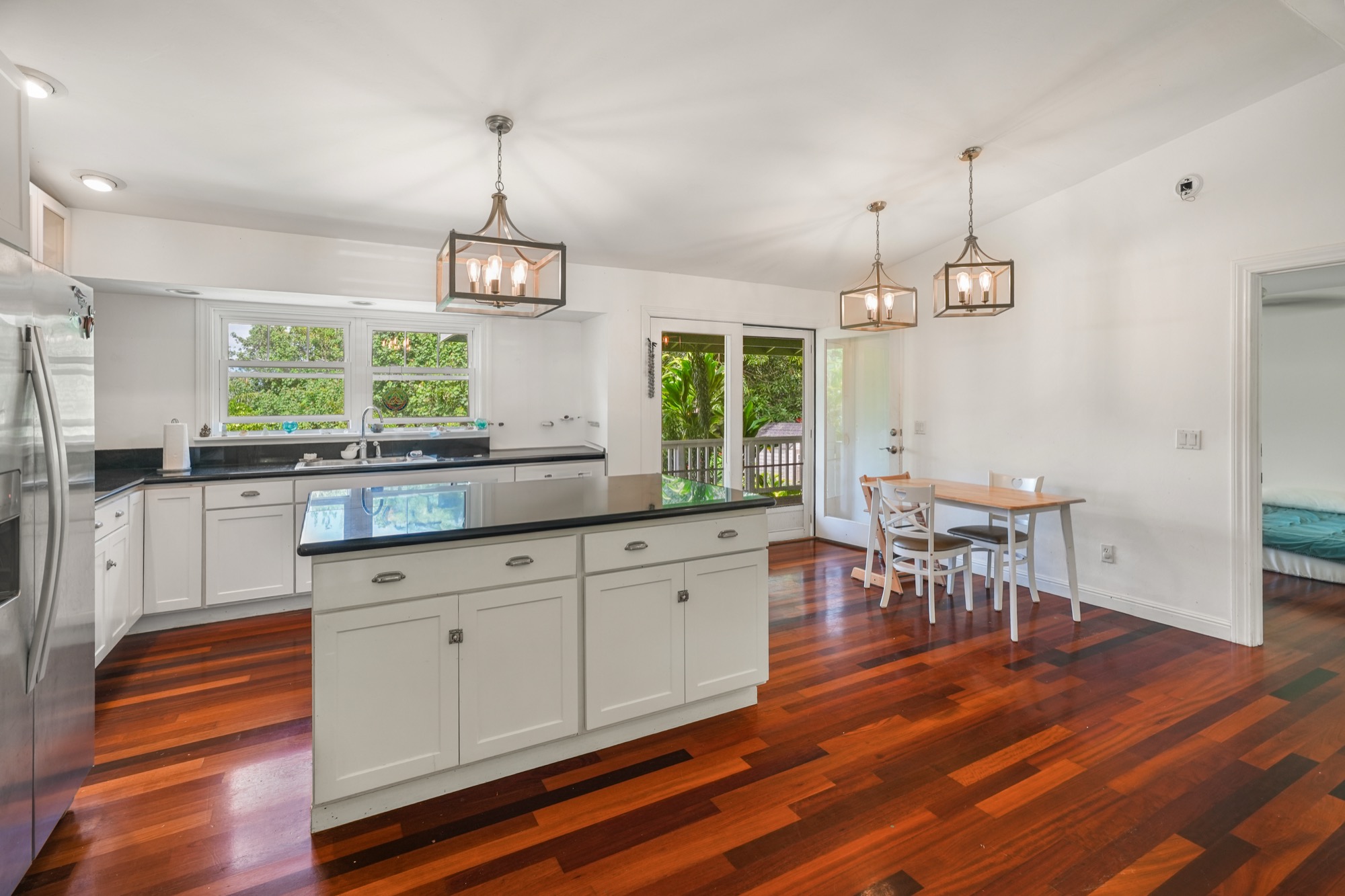 5974 Lokelani Road Kapaa, HI 96746 - Photo 5 of 24 a kitchen with stainless steel appliances granite countertop a stove a sink a dining table and chairs with wooden floor