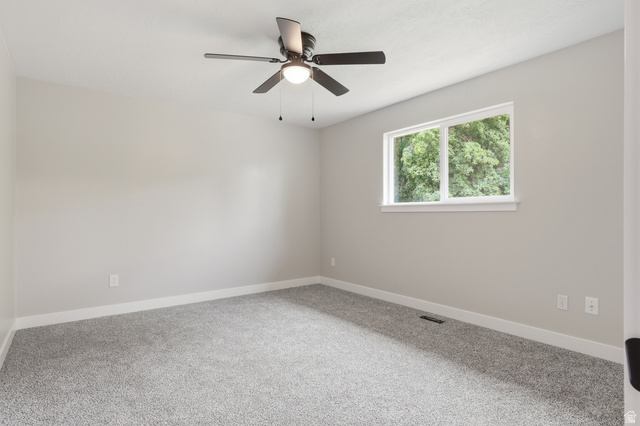629 King Circle Layton, UT 84041 - Photo 9 of 26 Spacious room featuring light gray wall paint, gray carpet, a ceiling fan with integrated lighting, and a double-pane window with white trim