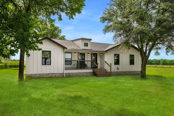 a view of a house with a yard and a tree