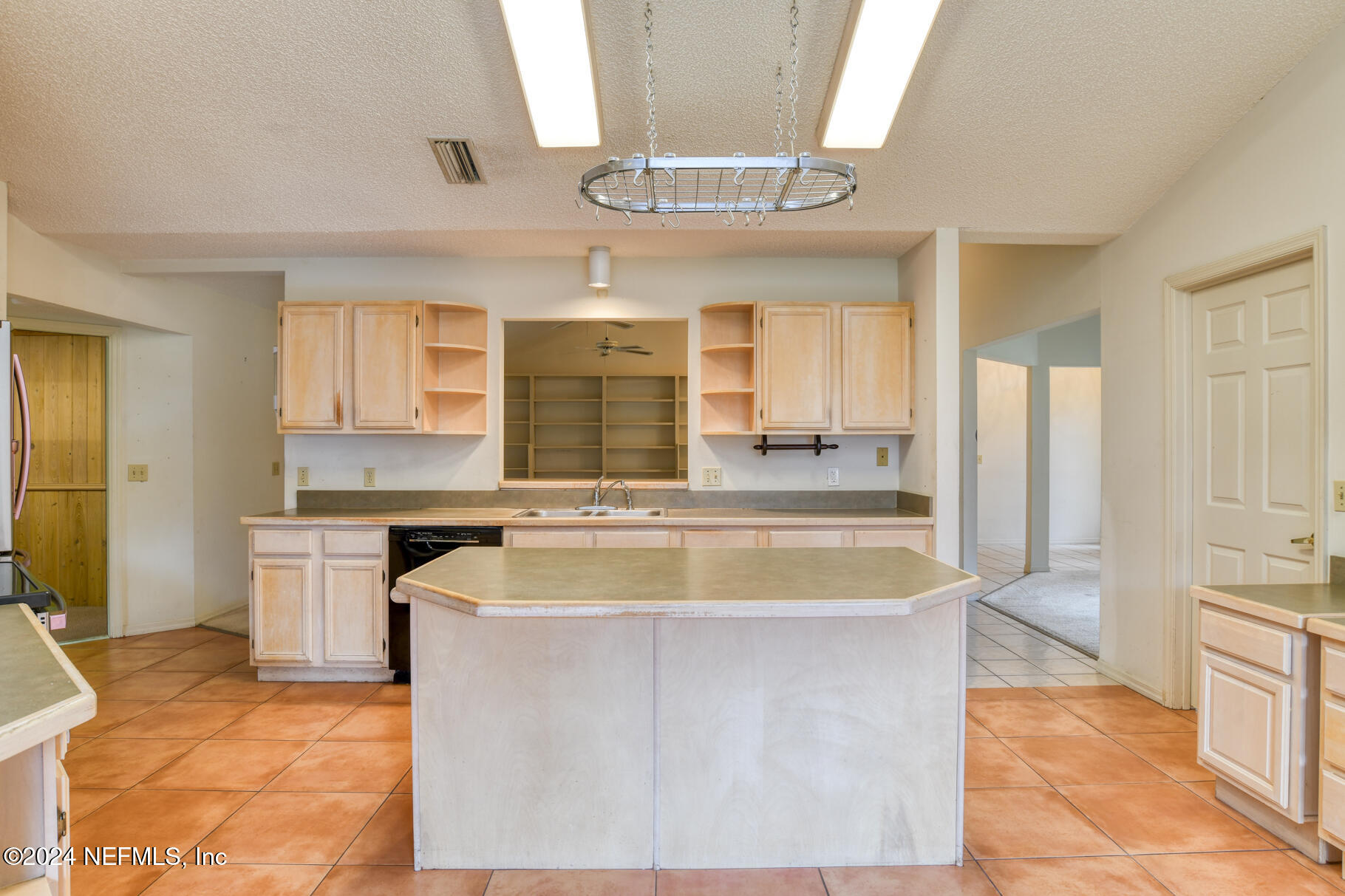 697 Standish Drive St. Augustine, FL 32086 - Photo 17 of 45 a view of a kitchen with kitchen island a sink granite counter tops and a view of living room