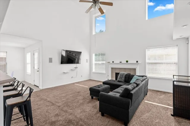 a living room with furniture a flat screen tv and kitchen view