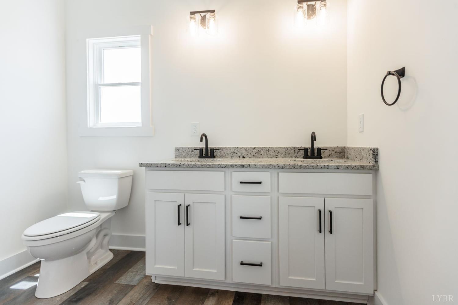 9740 Oakville Road Gladstone, VA 24553 - Photo 48 of 75 a bathroom with a granite countertop toilet sink and mirror